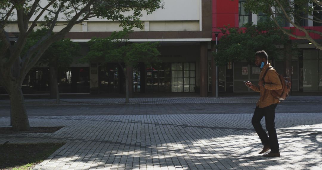 Businessman in city street using smartphone for communication