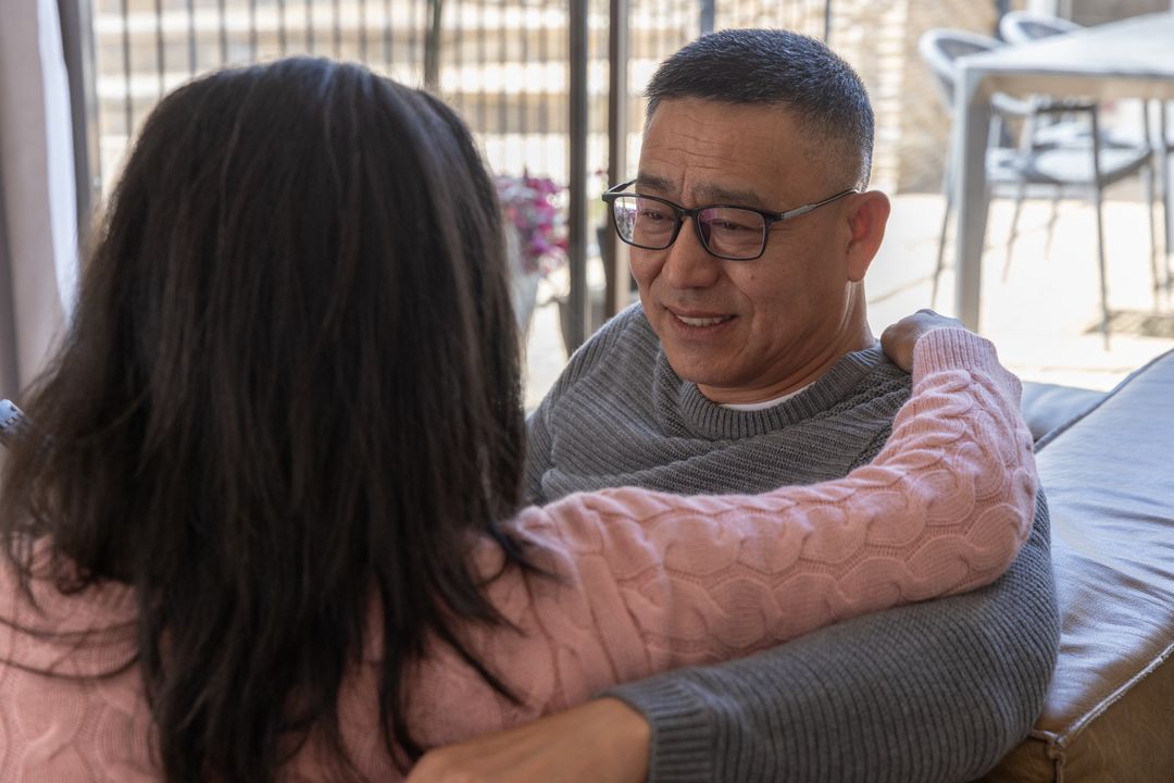 Couple Relaxing at Home in Cozy Living Room Embracing Each Other