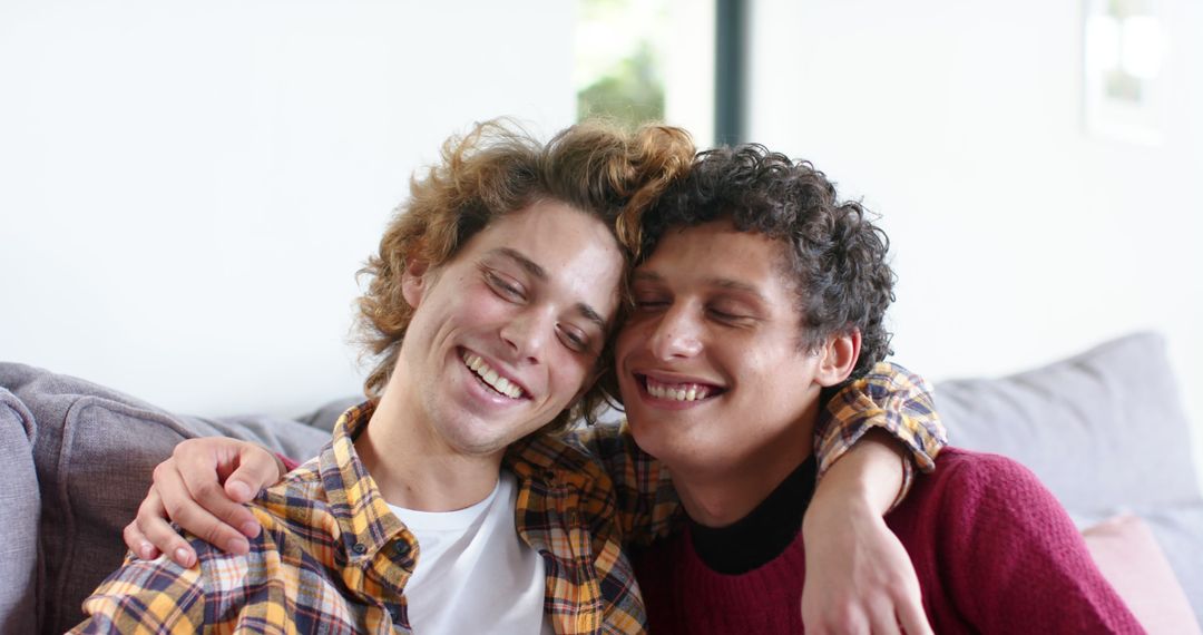 Happy Young Men Hugging and Smiling on Couch at Home - Free Images, Stock Photos and Pictures on Pikwizard.com