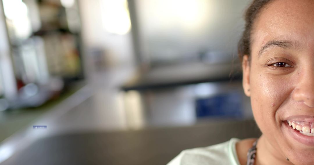 Smiling young woman close-up with soft bokeh communal room background and copy space warm natural li