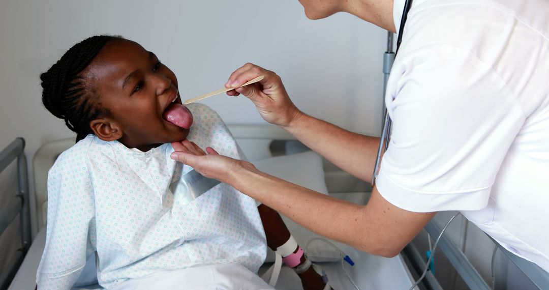 Pediatric Doctor Examining Young Patient's Throat in Hospital Bed - Free Images, Stock Photos and Pictures on Pikwizard.com