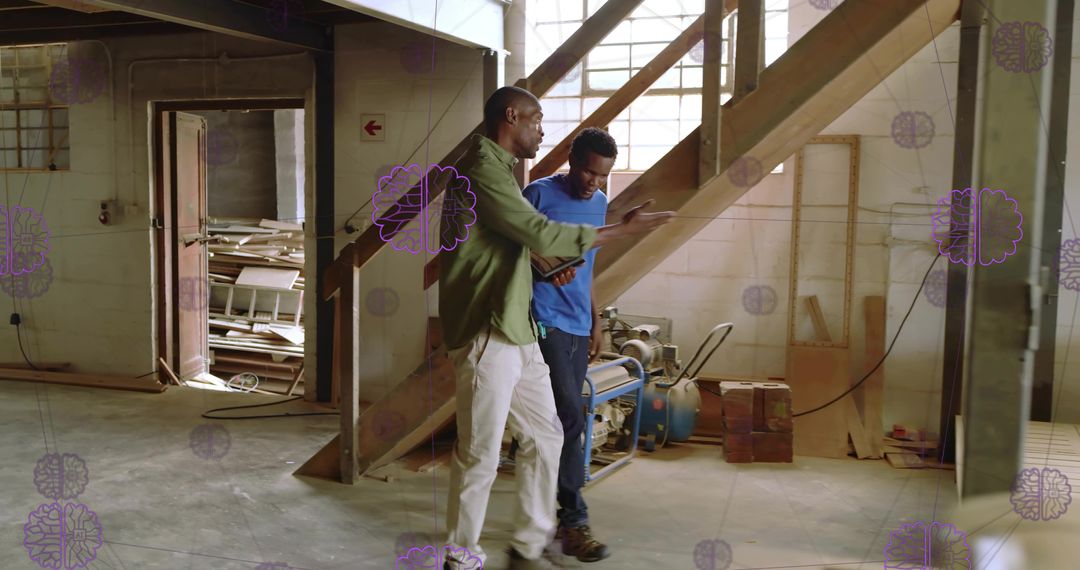 Contractors Discussing Wooden Staircase in Workshop Using Tablet for Renovation Plan
