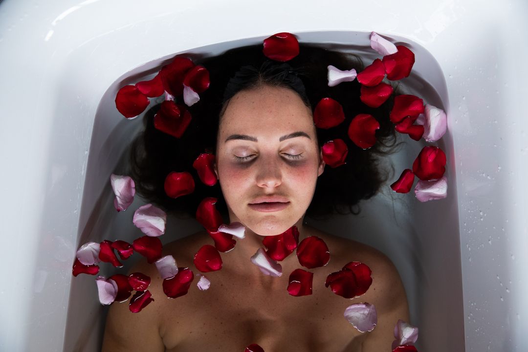 Young Woman Relaxing in Bathtub with Rose Petals - Free Images, Stock Photos and Pictures on Pikwizard.com
