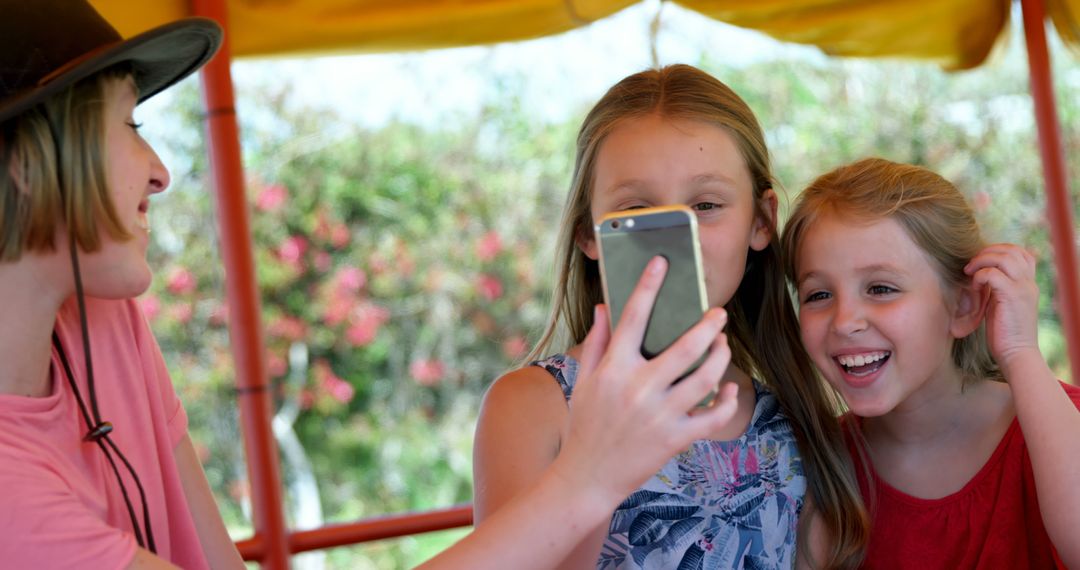 Mother and Daughters Laughing and Taking Selfie in Outdoor Setting - Free Images, Stock Photos and Pictures on Pikwizard.com