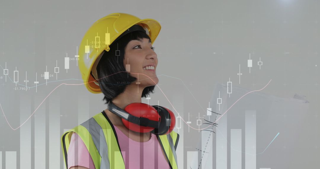 Asian Female Engineer with Safety Gear Analyzing Data Graphs