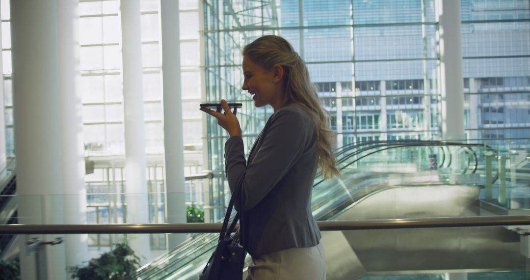 Businesswoman Talking on Phone in Modern Office Atrium - Free Images, Stock Photos and Pictures on Pikwizard.com