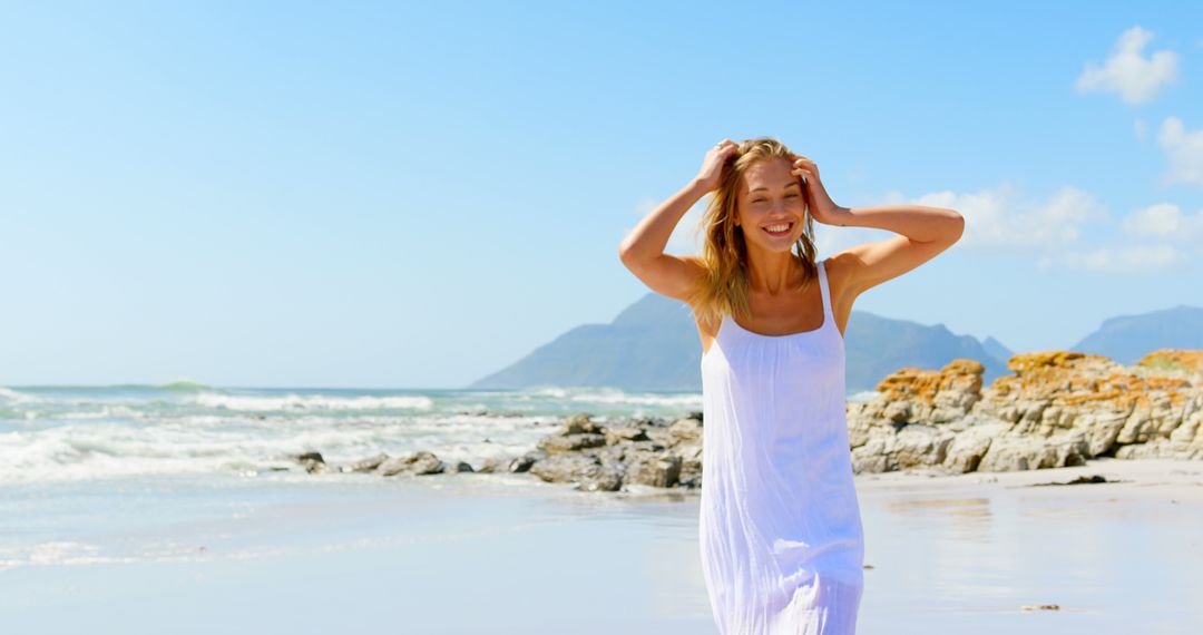 Happy young woman enjoying a sunny day on a beach - Free Images, Stock Photos and Pictures on Pikwizard.com