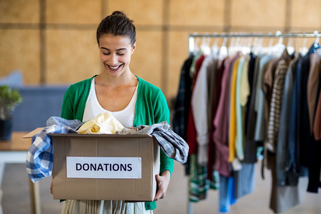 Woman Donating Clothes in Office - Free Images, Stock Photos and Pictures on Pikwizard.com