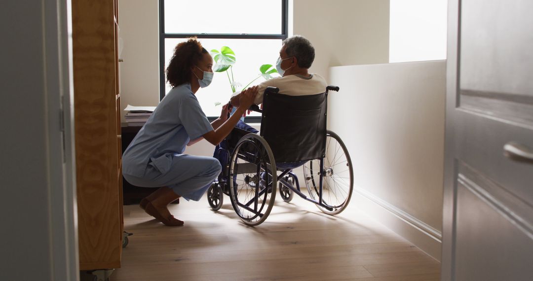 Nurse Caring for Senior Man in Wheelchair in Hospital Corridor - Free Images, Stock Photos and Pictures on Pikwizard.com