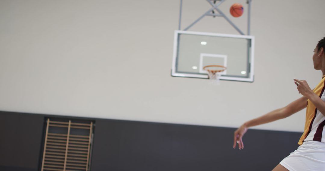 Basketball Player Throwing Ball at Hoop in Gymnasium - Free Images, Stock Photos and Pictures on Pikwizard.com