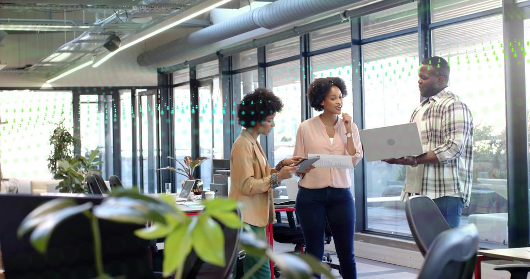 Colleagues Collaborating and Reviewing Project Documents in Modern Open-Plan Office