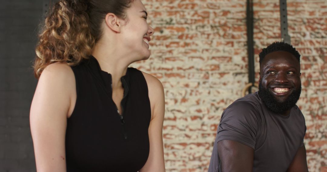Diverse Workout Partners Enjoying a Break in Urban Gym