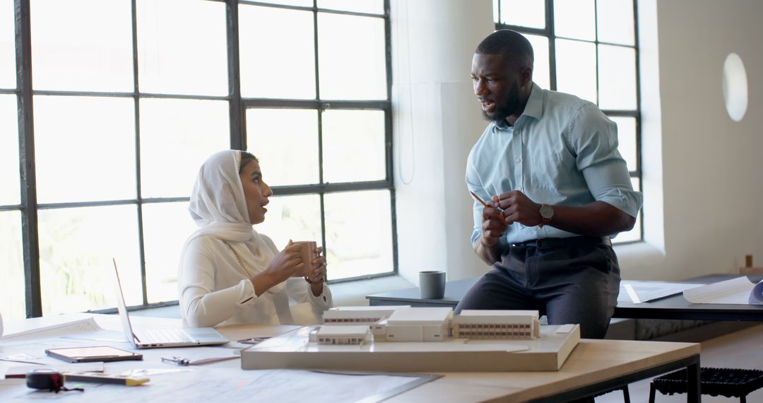 Business Colleagues Engaging in Office Meeting with Architectural Plans