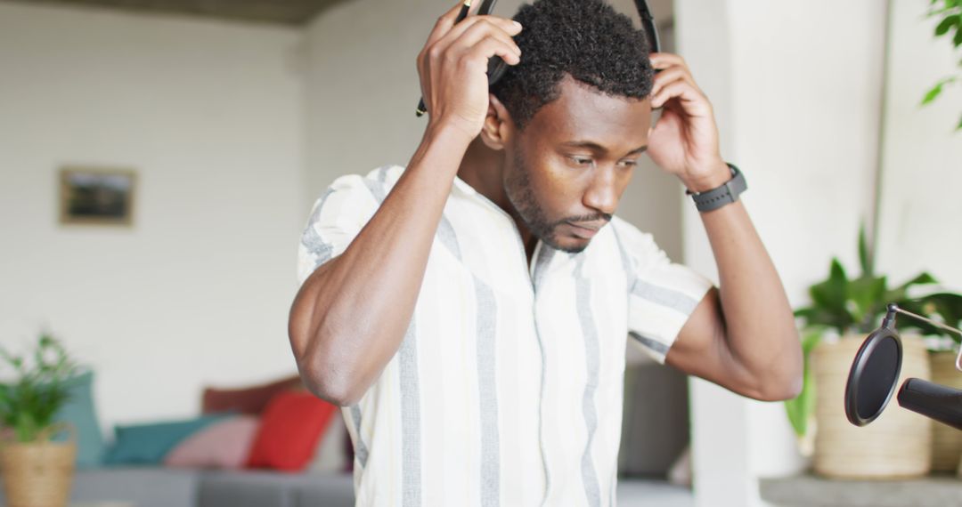 African American man adjusting his headphones during recording session - Free Images, Stock Photos and Pictures on Pikwizard.com