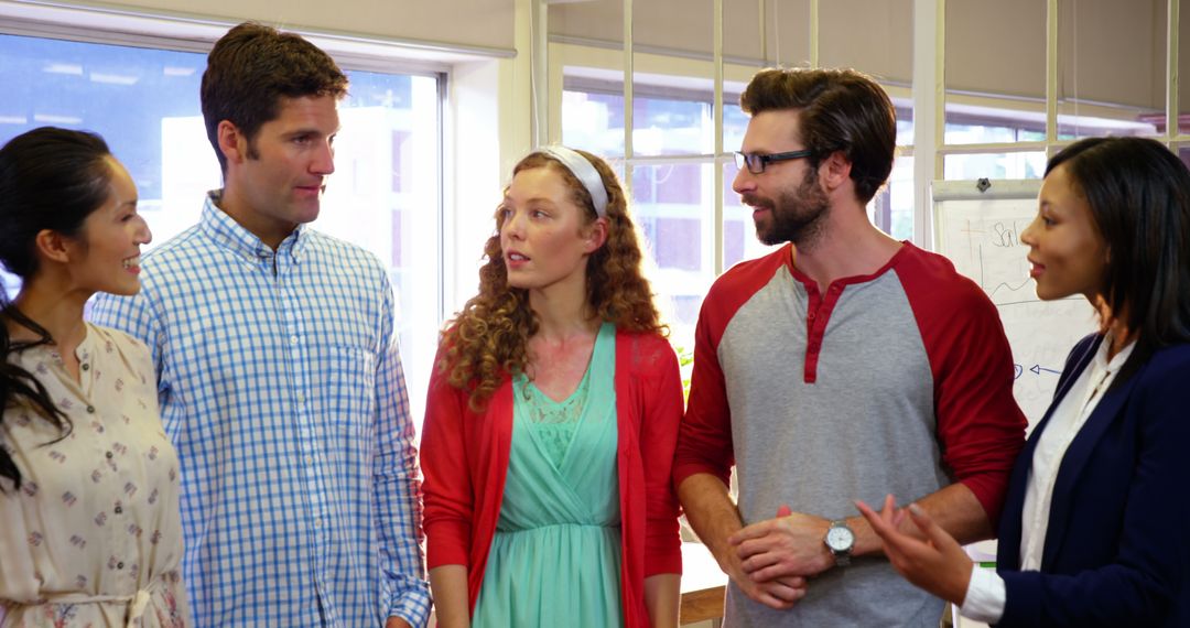 Diverse Group Engaged in Lively Conversation in Bright Office Space