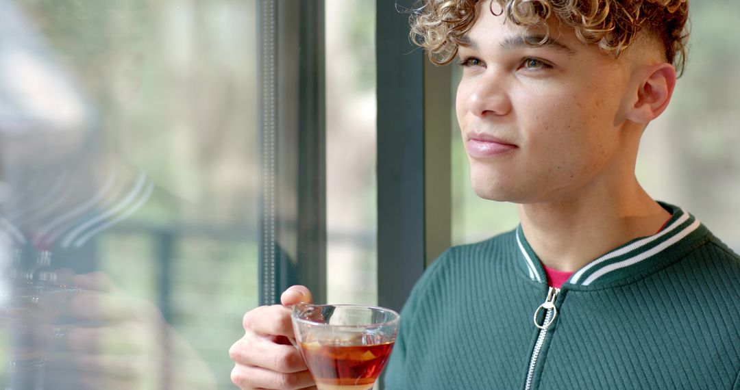 Man Enjoying Warm Beverage by Window with View