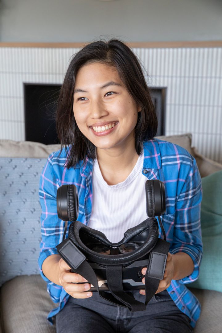 Smiling Woman Relaxing at Home with Virtual Reality Headset