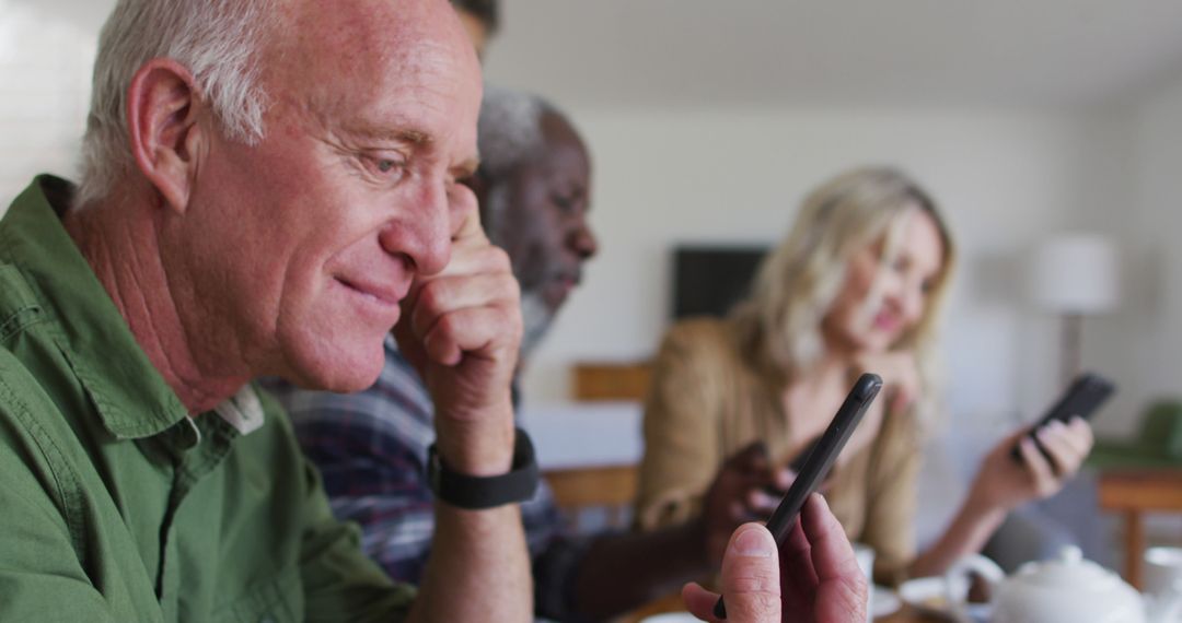 Senior Friends Engaging with Smartphones During Gathering - Free Images, Stock Photos and Pictures on Pikwizard.com