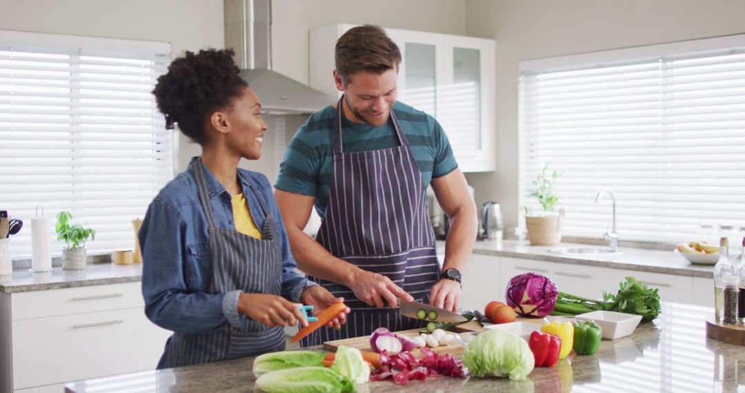 Image of happy diverse couple preparing meal, cutting vegetables in kitchen - Free Images, Stock Photos and Pictures on Pikwizard.com