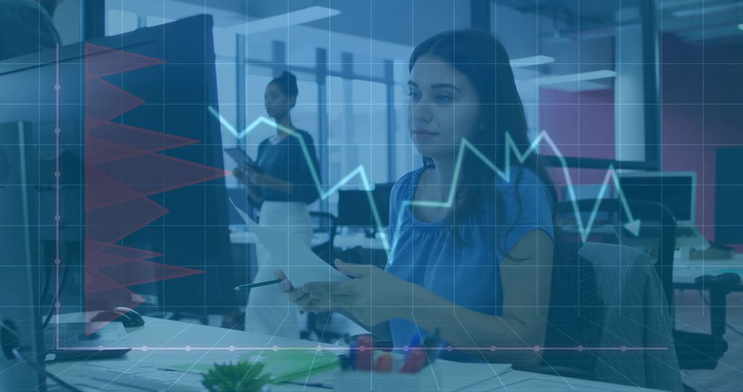 Businesswoman reviewing data with financial dashboard overlay in collaborative open office