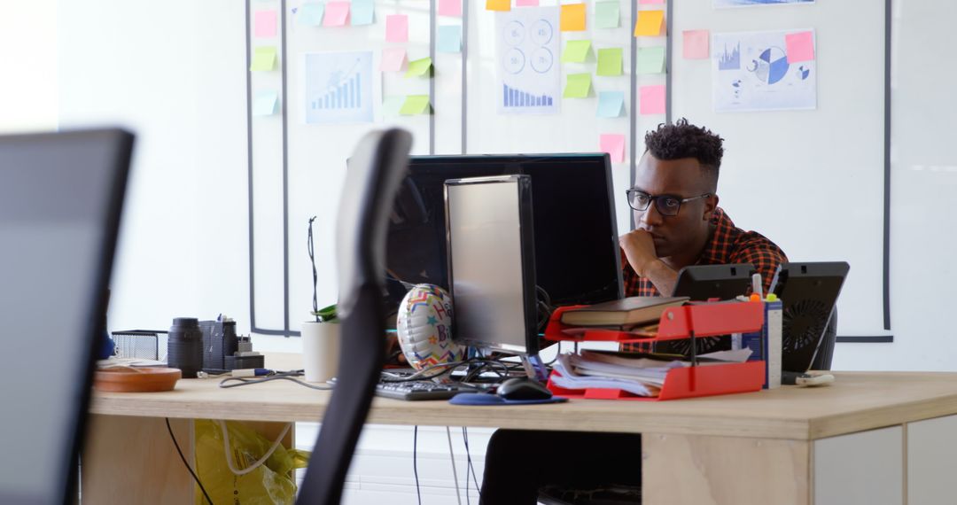 Thoughtful Businessman Analyzing Project on Desktop in Office