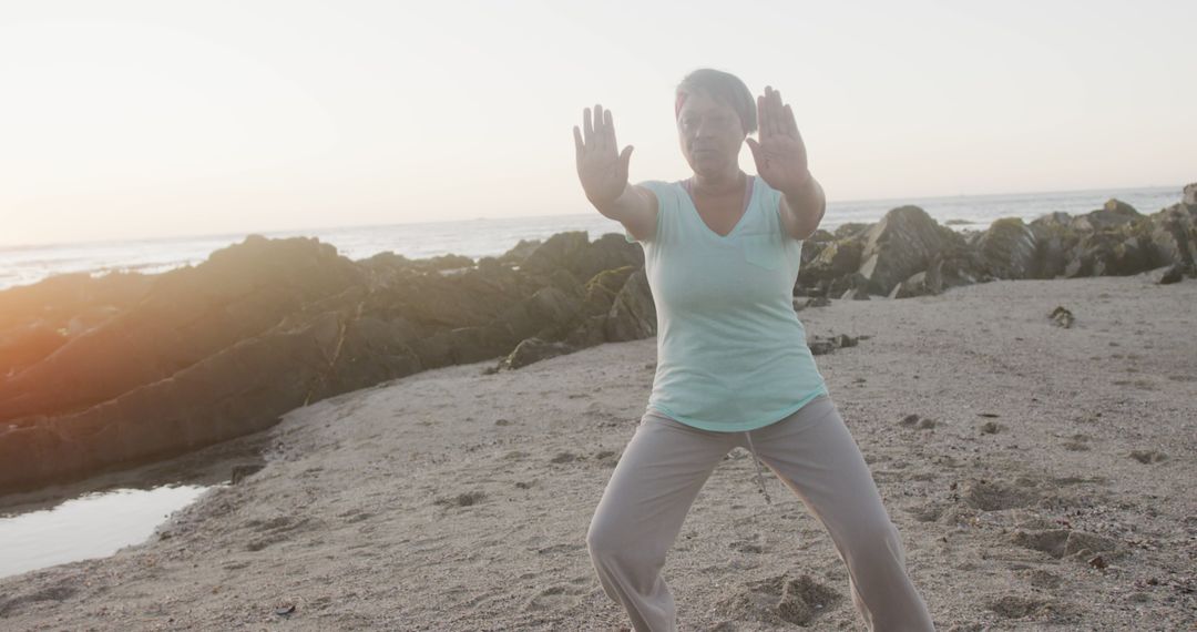 Senior Woman Practicing Tai Chi on Beach at Sunrise - Free Images, Stock Photos and Pictures on Pikwizard.com