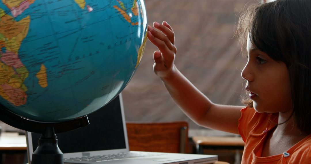 Curious Child Exploring Globe in Classroom Setting - Free Images, Stock Photos and Pictures on Pikwizard.com