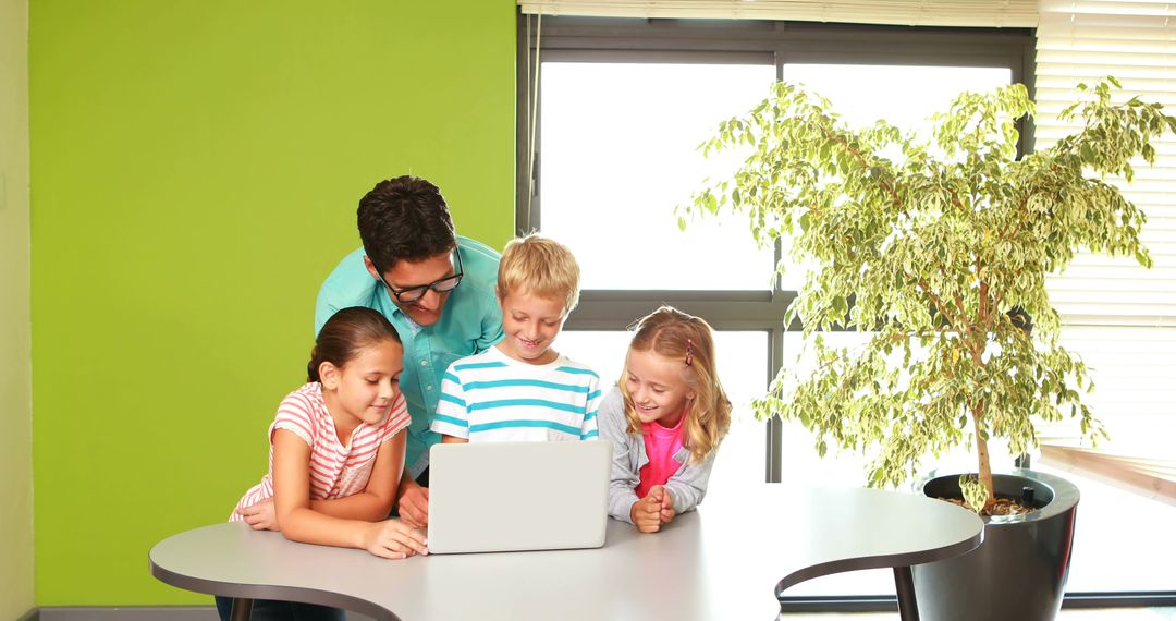 Male Teacher Engaging with Happy Children Learning on Laptop - Free Images, Stock Photos and Pictures on Pikwizard.com