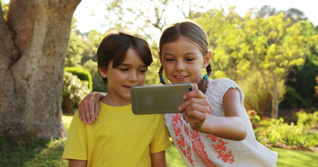 Cheerful Kids Taking Selfie in Sunny Park - Free Images, Stock Photos and Pictures on Pikwizard.com