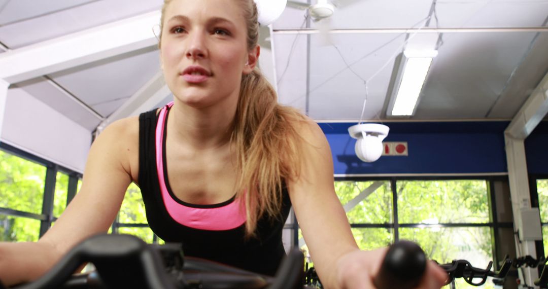 Young Woman Exercising on Stationary Bike in Gym - Free Images, Stock Photos and Pictures on Pikwizard.com