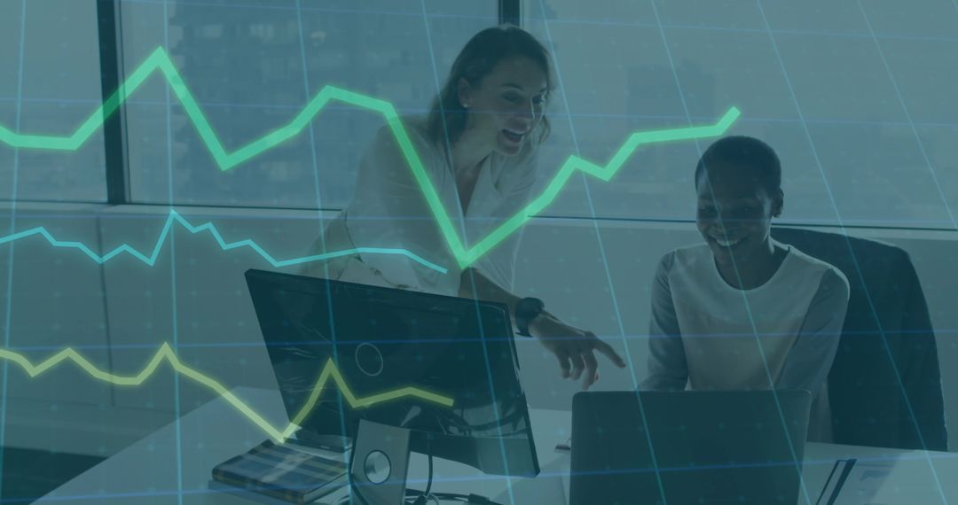 Two Women Collaborating on Data Analytics with Laptop Displaying Green Charts in Office