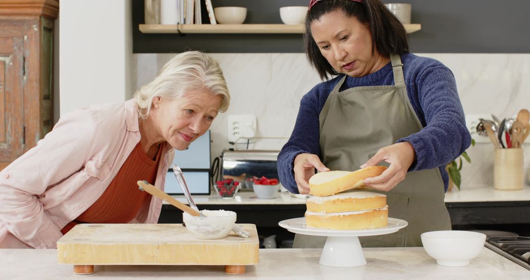 Senior Women Collaborating to Assemble Layer Cake in Cozy Kitchen