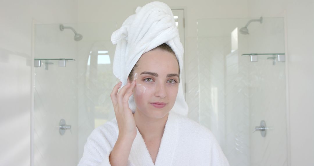 Young Woman Applying Face Cream in Bright Bathroom - Free Images, Stock Photos and Pictures on Pikwizard.com