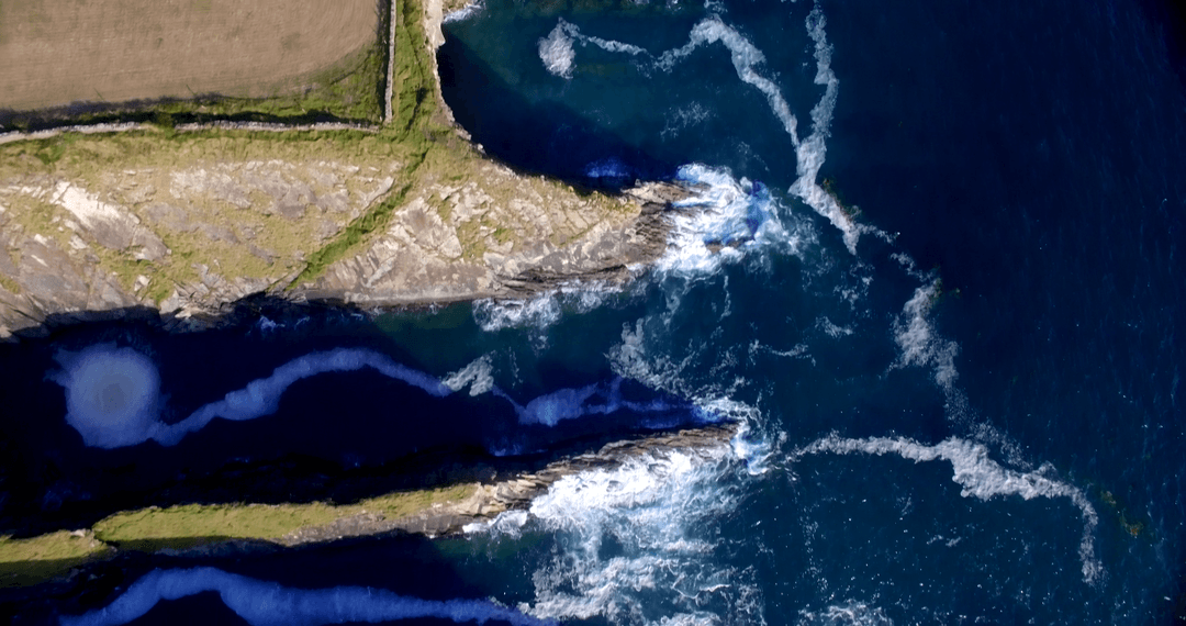 Transparent Ocean Waves Meeting Rugged Rock Formations