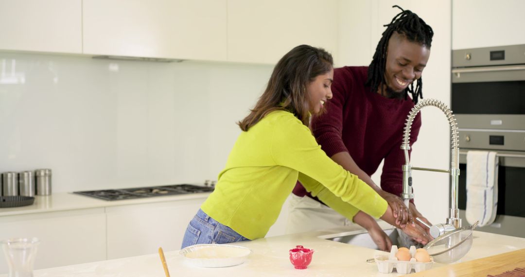 Rinsing hands together while baking in bright modern kitchen with spring faucet