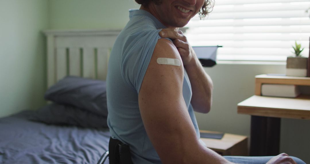 Young Man Showing Bandage on Arm After Vaccination in Bedroom - Free Images, Stock Photos and Pictures on Pikwizard.com