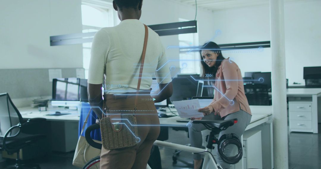 Colleagues Collaborating Beside Bicycle in Modern Open-Plan Office Discussing Documents