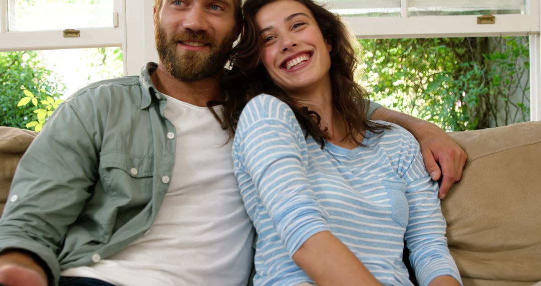 Happy Couple Sitting On Couch Smiling Together - Free Images, Stock Photos and Pictures on Pikwizard.com