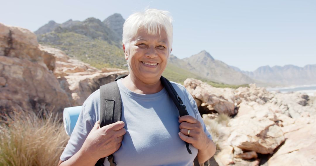 Senior Woman Hiking in Mountainous Landscape with Backpack - Free Images, Stock Photos and Pictures on Pikwizard.com