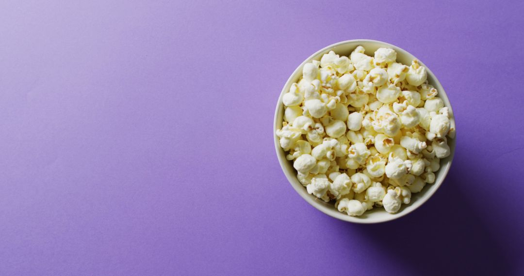 Close Up of Popcorn in Bowl on Purple Background for Snack or Movie Concept - Free Images, Stock Photos and Pictures on Pikwizard.com