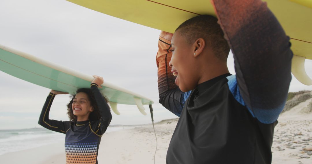 Two Black Women Holding Surfboards on a Sandy Beach - Free Images, Stock Photos and Pictures on Pikwizard.com