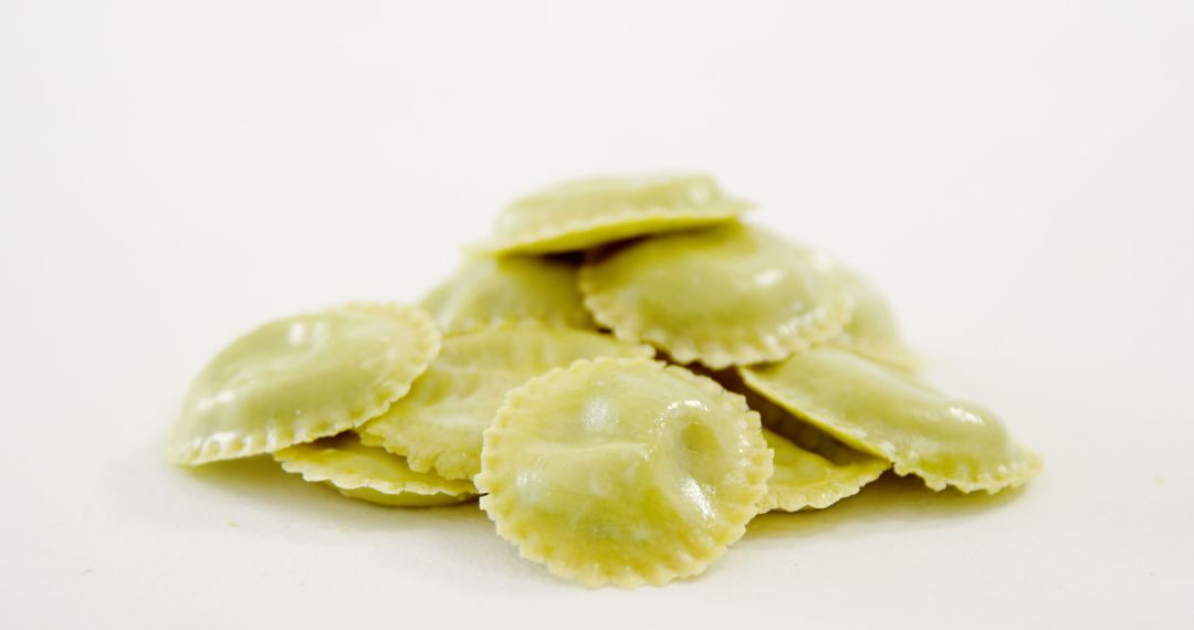 A pile of freshly made ravioli pasta is showcased against a white background, with copy space - Free Images, Stock Photos and Pictures on Pikwizard.com