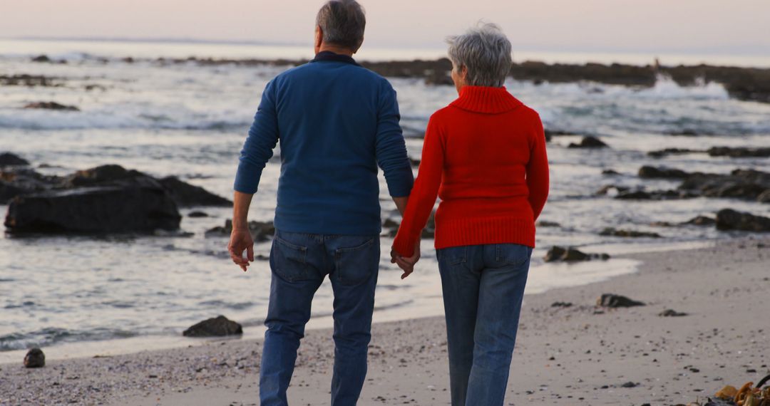 Senior caucasian couple holding hands and walking on beach by sea at sunset - Free Images, Stock Photos and Pictures on Pikwizard.com