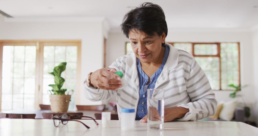 Asian senior woman checking her medicine containers in the living room at home - Free Images, Stock Photos and Pictures on Pikwizard.com