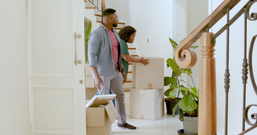 Couple Moving into New Home Surrounded by Boxes and Plants