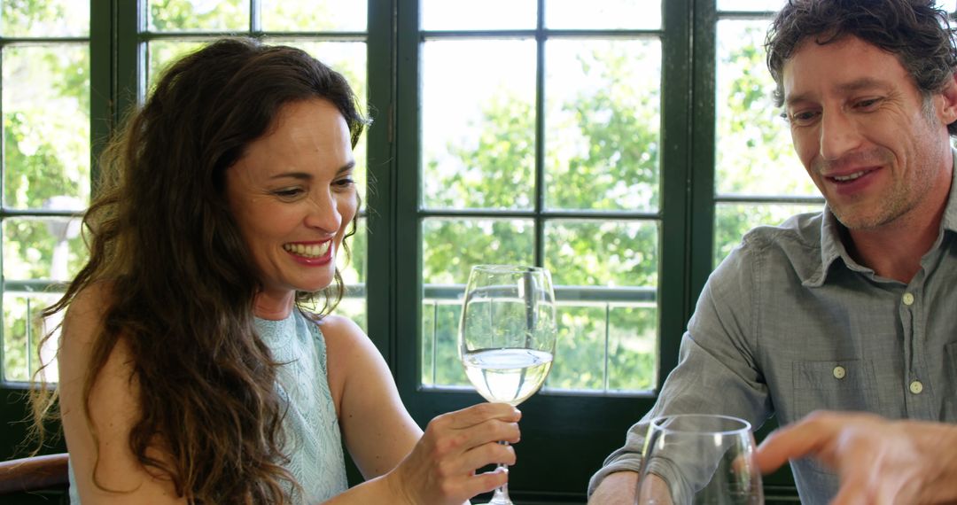 Couple sharing white wine and enjoying conversation at home - Free Images, Stock Photos and Pictures on Pikwizard.com