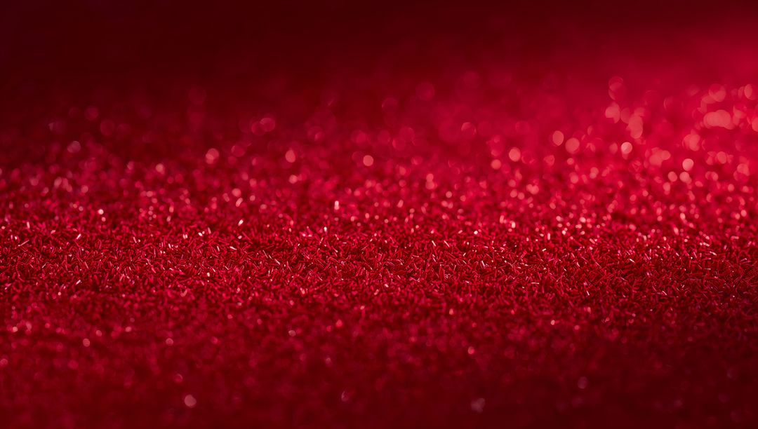 Shimmering Red Glitter Surface Catching Light with Bokeh Sparkle and Metallic Texture
