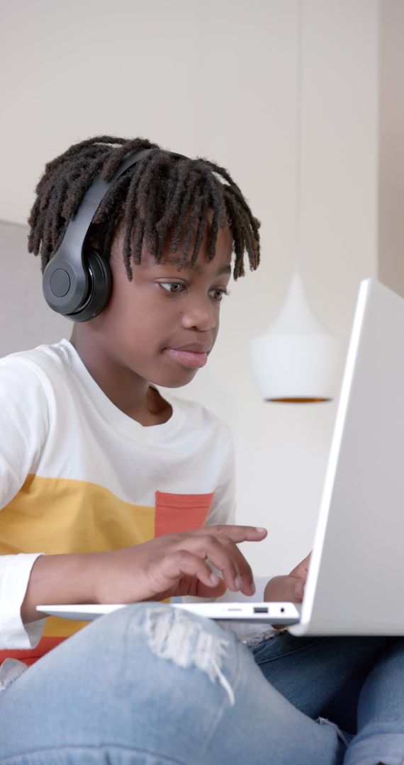 Child Engaged in Online Learning at Home with Laptop and Headphones