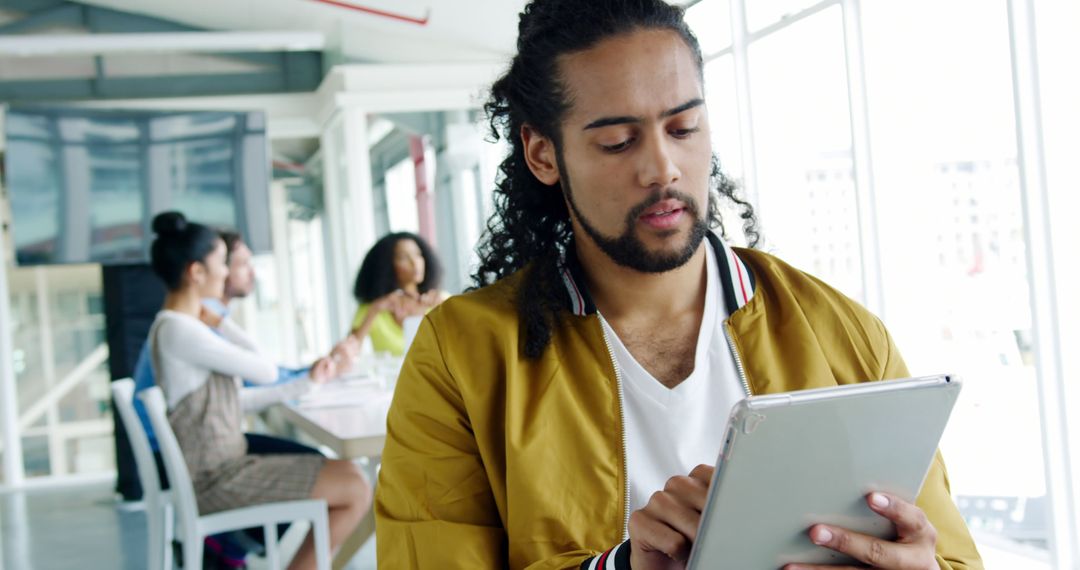 Young Professional Using Tablet in Modern Office