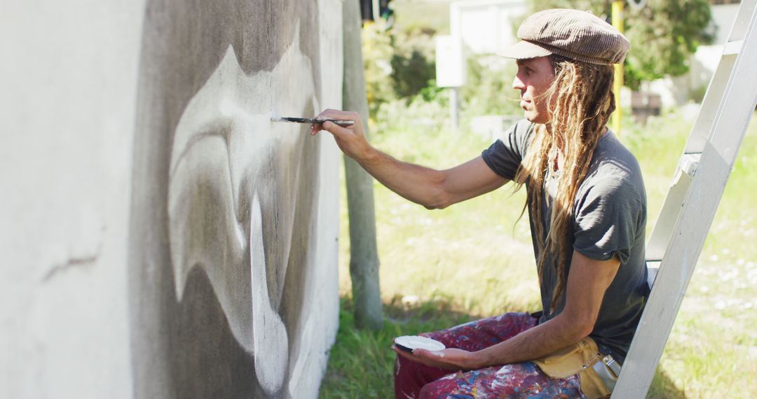 Young Male Artist Painting Mural on Outdoor Wall - Free Images, Stock Photos and Pictures on Pikwizard.com